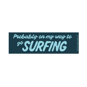 A rectangular bumper sticker with the text 'Probably on my way to go SURFING' in light blue lettering on a dark teal background, shown on a plain white background.